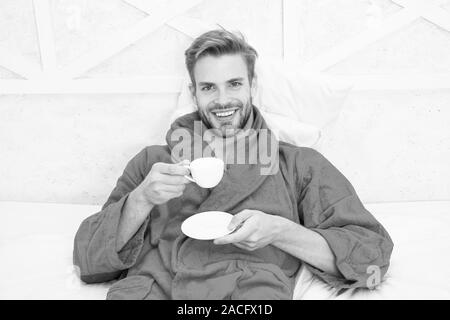 Kaffee am Morgen genießen. Gerne morgen. Schöner Mann trinken Kaffee am Morgen. Happy bärtiger Mann im Bett. Gute Laune. Ab Tag mit guten Kaffee. Entspannt zu Hause. Angenehme Momente. Gourmet Espresso. Stockfoto