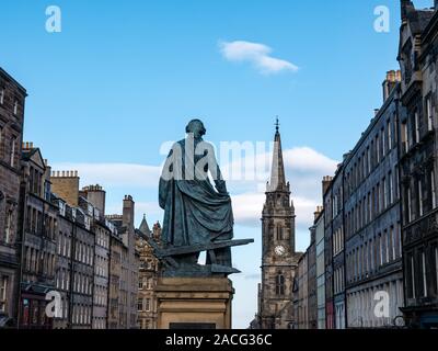 Adam Smith Statue und historischen Gebäuden entlang der Royal Mile an einem sonnigen Tag mit blauem Himmel, Edinburgh, Schottland, Großbritannien Stockfoto