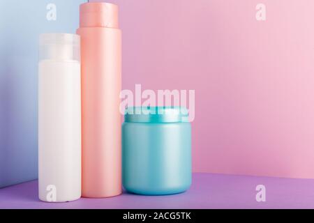 Satz von kosmetischen Produkten auf rosa Hintergrund. Kosmetik Paket Sammlung für Shampoo, Maske, Conditioner, Duschgel. Rosa, Weiß, Blau Kunststoff Flaschen Stockfoto