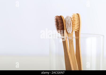 Natürliche Bambus Zahnbürsten in Glas auf weißem Hintergrund. Satz von biologisch abbaubaren natürlichen Bambus Zahnbürsten. Umweltfreundliche, Null Abfall, Zahnpflege Stockfoto