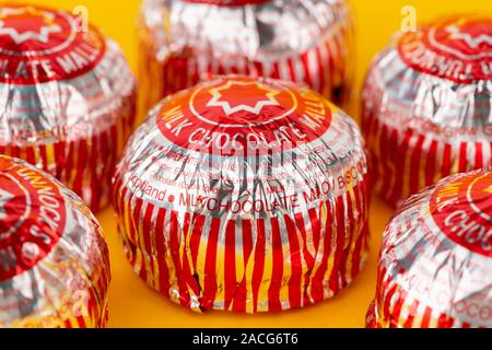 Eine Reihe von Tunnock's Milch Schokolade Kaffee Kuchen Schuß auf einen gelben Hintergrund. Stockfoto