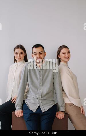 Portrait von drei Personen sitzen auf der Kante einer Tabelle Stockfoto