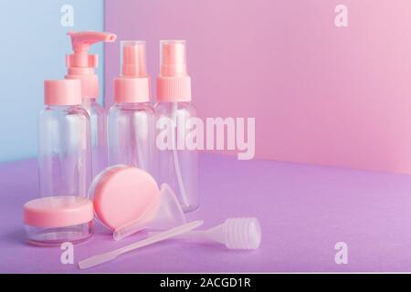 Plastikflaschen für Verpackungen Hygiene Produkte, hausgemachte Naturkosmetik, Travel Kit Pflegeprodukte. Flasche, Glas auf Farbe rosa Hintergrund. Kosmetische Stockfoto