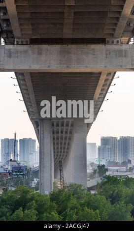 Ho Chi Minh City, Vietnam - 13. März 2019: Sonnenuntergang Himmel geschossen über Song Sai Gon River. Segeln unter Phu My Brücke mit Hochhaus Gebäude Stockfoto