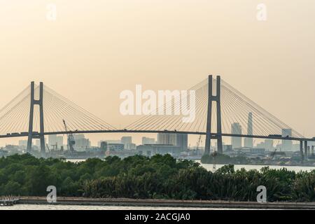 Ho Chi Minh City, Vietnam - 13. März 2019: Sonnenuntergang Himmel geschossen über Song Sai Gon River. Phu My Brücke mit downtown Wolkenkratzer bauten auf Ho Stockfoto