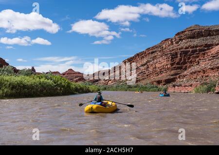 Eine Familie Rafting Trip durch die Schlucht des San Juan River im Südosten von Utah, USA. Im Hintergrund ist Mexican Hat Rock. Stockfoto
