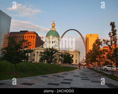 ST. LOUIS, Missouri - 9. JULI 2018: Ein paar Radfahrer fahren Seite an Seite, von hinten durch den berühmten Gateway Arch umrahmt mit der historischen Altstadt Courth Stockfoto