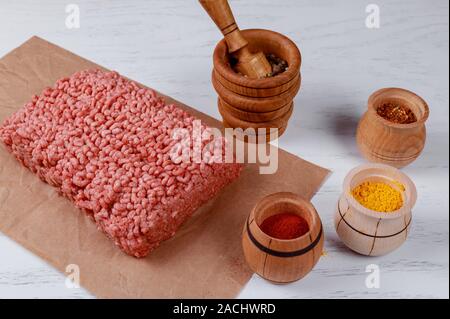 Rohes Hackfleisch/Faschiertes Rindfleisch mit verschiedenen Gewürzen ein Brett Stockfoto