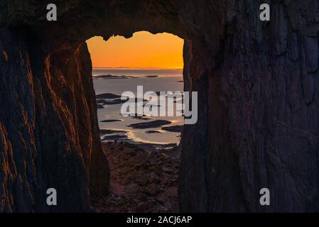 Sonnenuntergang an der Küste Nordnorwegens, von innen gesehen in einer Höhle. Stockfoto