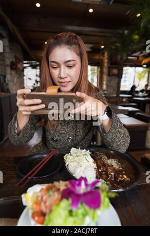 Mit smartphone ein Foto von Essen im Restaurant Frau Stockfoto