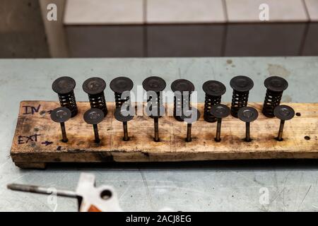 Ventil von einem Auto Motor mit Carbon Einlagen und in Öl mit Federn von einem Fahrzeug auf einer Werkbank während einer Überholung in einem Workshop extrahiert. Autom. Stockfoto