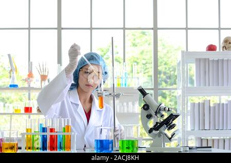 Die Wissenschaftlerin im Labor zu tun, indem sie die Synthese von Verbindungen mit der Pipette in einem Reagenzglas. Stockfoto