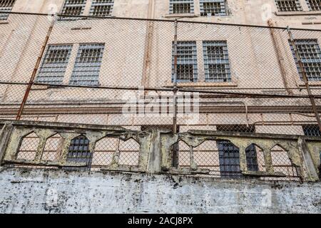 Verfallenden Mauern und Zaun im Alcatraz Island National Historic Landmark, San Francisco Bay, Kalifornien, USA. Stockfoto