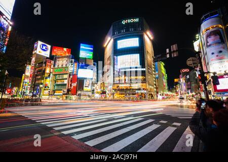 TOKYO, Japan - 25. März 2019: Der leichte Wanderwege auf der Shibuya berühmten Kreuzung Straße bei Nacht in Tokio, Japan. Stockfoto