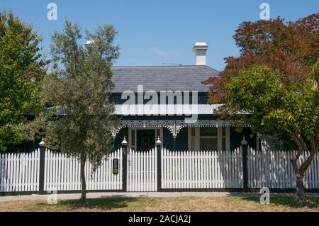 Eine authentially restaurierten Viktorianischen Holzhaus in einem Vorort von Melbourne, Australien, mit Schieferdach, Veranda, Bügeleisen lacework und Lattenzaun. Stockfoto