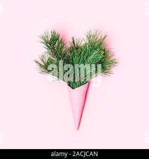 Blumenstrauß aus Flauschigen nadelholz Verzweigungen in einer Eiswaffel. Minimale urlaub Konzept. Stockfoto