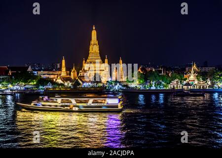 Bootsfahrten entlang den Fluss Chao Phraya Vergangenheit Wat Arun, bei Dämmerung in Bangkok Die Hauptstadt von Thailand beleuchtet. Stockfoto