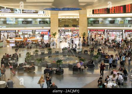 Juli 13, 2014. Lod, Israel. Ben Gurion Flughafen bekannt als Natbag. Viel beschäftigte Menschen, die rund um den Brunnen in der Mitte der Halle. Viele Geschäfte rund um. Trav Stockfoto