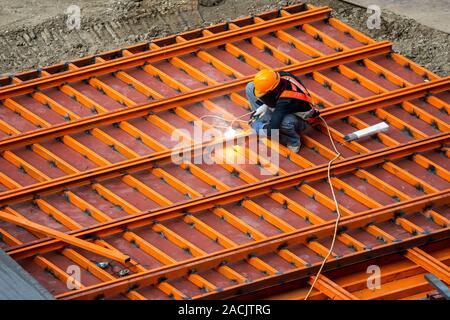 Ein Bauarbeiter, die eine Arbeit tun, wie Malen Schweißen in einer Baustelle. Stockfoto