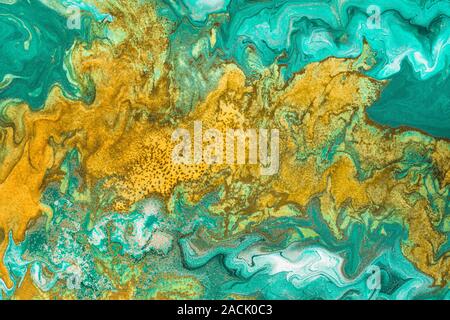 Abstrakte gelbe Wellen auf grünem Hintergrund mit goldenen Einschlüssen. Frei fließende Farbe. Acryl Flüssigkeit Art. Stockfoto