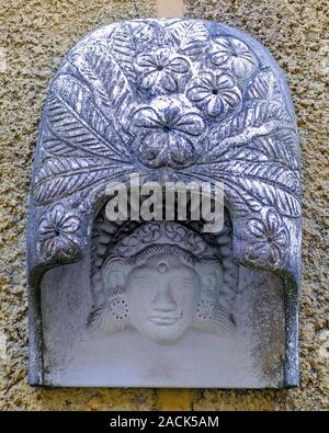 Straßenlaterne mit Schnitzereien in der Form von Blumen und einem weiblichen Porträt eingerichtet. Dekoration der Außenansicht bei Bali Stockfoto