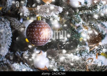 Christmas Ball auf einem snowy christmas tree branch auf einem Winter Hintergrund. Weihnachten Konzept. Stockfoto
