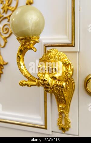 Golden Türklopfer in der Form von Lion auf einer hölzernen Tür. Stockfoto