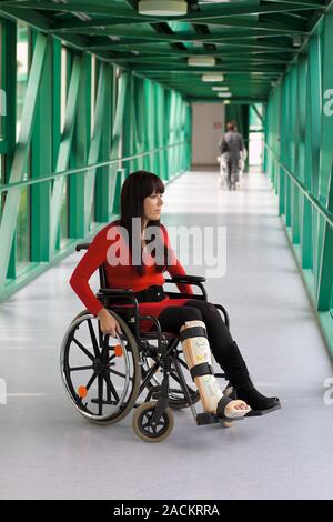 Frau mit Gips Bein und Rollstuhl im Krankenhaus Stockfoto