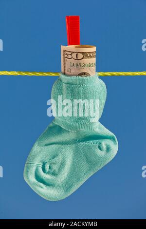 Baby Socken auf die Wäscheleine mit Dollar Stockfoto
