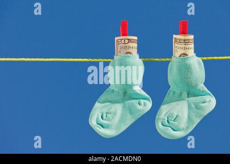Baby Socken auf die Wäscheleine mit Dollar Banknoten Stockfoto