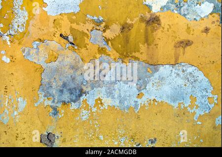 Abblätternde gelbe Farbe auf ein Gebäude. Symbol Foto für Feuchtigkeit und feuchte Wände. Stockfoto