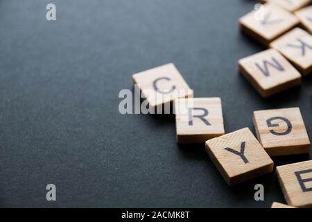 Stapel von Holz- Buchstaben auf der Oberfläche von einem dunklen Hintergrund, selektiver Fokus Stockfoto
