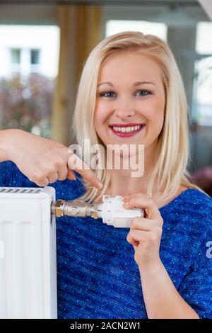 Frau senkt die Raumtemperatur Stockfoto