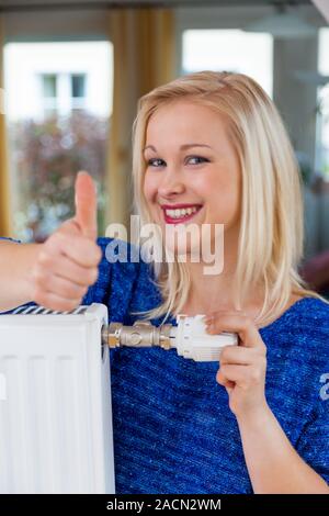 Frau senkt die Raumtemperatur Stockfoto