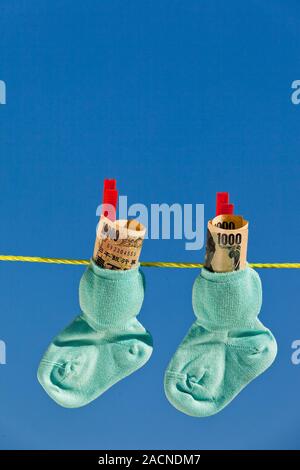 Baby Socken auf die Wäscheleine mit Yen Banknoten Stockfoto