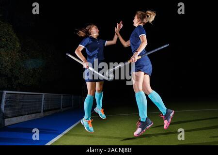 Zwei weibliche Hockey Spieler feiern den Sieg Stockfoto