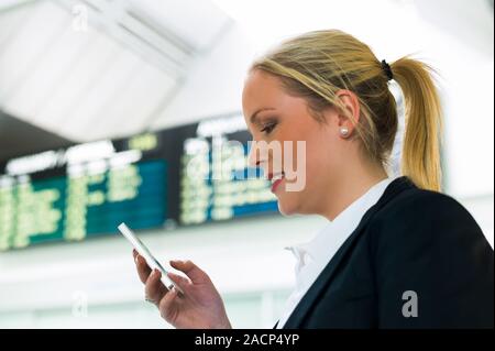 Frau schreibt eine SMS mit Ihrem Mobiltelefon Stockfoto