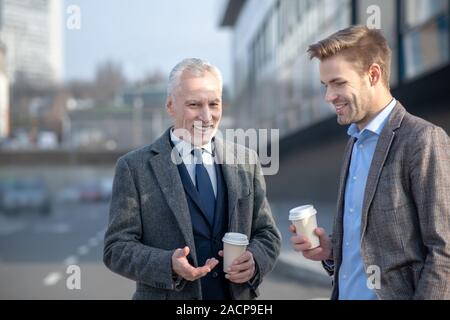 Junge Unternehmer und seine Reife Mentor sprechen auf der Straße Stockfoto