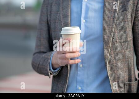Mann in ein blaues T-Shirt mit einer Tasse Kaffee Stockfoto
