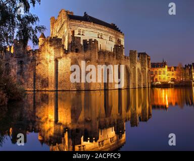 Beleuchtete Burg Gravensteen in der Dämmerung mit Wasser Reflexion, Wasserburg, Gent, Flandern, Belgien Stockfoto