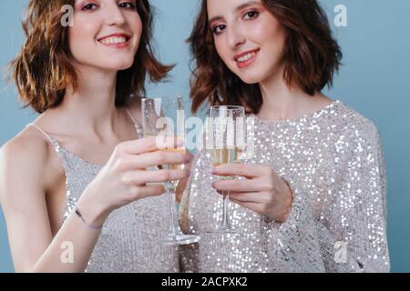 Zwillingsschwestern in Abend glänzend Kleider Spaß Stockfoto