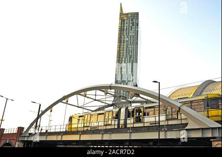 Manchester U-Straßenbahn überqueren Brücke vor der Beetham Tower Apartments und Hilton Hotel Stockfoto