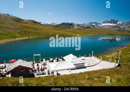 Leute, entspannen Sie an der Bar und Restaurant von der Ouillette See in der Nähe der Iseran, Val d'Isère, Savoie (73), Auvergne-Rhone-Alpes, Frankreich Stockfoto