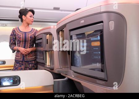 Ein Flugbegleiter steht in der Business Class Kabine eines Airbus A350-900 Flugzeuge von Singapore Airlines Stockfoto