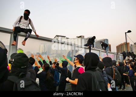 Hongkong, China. 01., Dezember 2019. Tausende von pro-demokratischen Demonstranten melden Sie den friedlichen Marsch von Tsim Sha Tsui, Hung Hom. Hier die demonstranten haben Aufstieg über eine Landstraße Wand der Polizei, die nach vorn drücken, sind zu vermeiden. Stockfoto