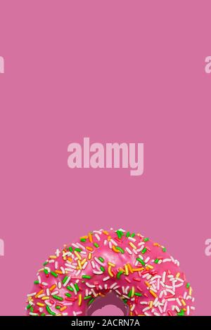 Süße himbeere Donuts oder Krapfen mit Puderzucker und mit bunten Zucker Streusel auf Pastell rosa Hintergrund. Kreative minimalen Begriff. Flach, Ansicht von oben Stockfoto