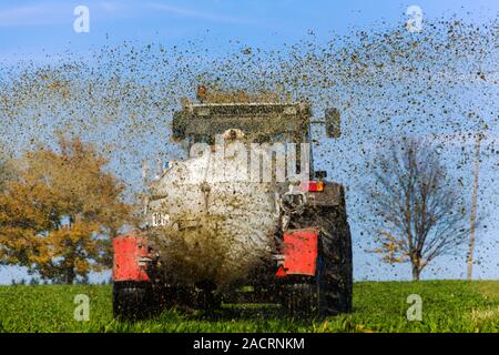 Traktor befruchtet ein Feld mit Gülle Stockfoto