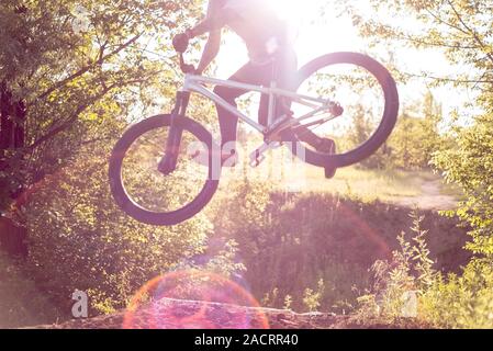 Coole Stunts von einem radprofi durchgeführt - Athlet. In einem Wald Sportplatz, mit Sprungschanzen, springen in den Himmel. Radfahren im Wald. Radfahren Stockfoto