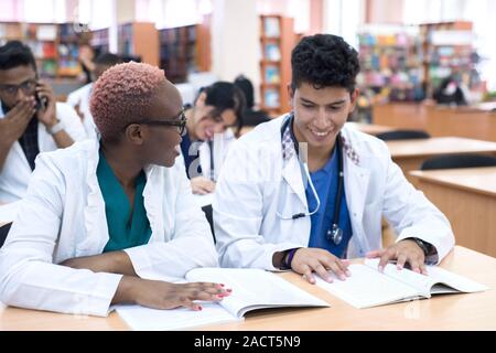 Medizinische Ausbildung, Gesundheitswesen, Menschen und Medizin Konzept - Gruppe von Happy Ärzte oder Praktikanten mit Mentor treffen und sich Notizen im Krankenhaus Stockfoto