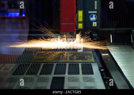 CNC-Laserschneidanlage schneiden Blech mit Funkenflug Stockfoto